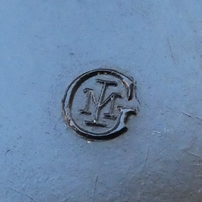 Figure 5 — The intertwined "GIM" moulder's mark under a Lightning's Bakelite stand.