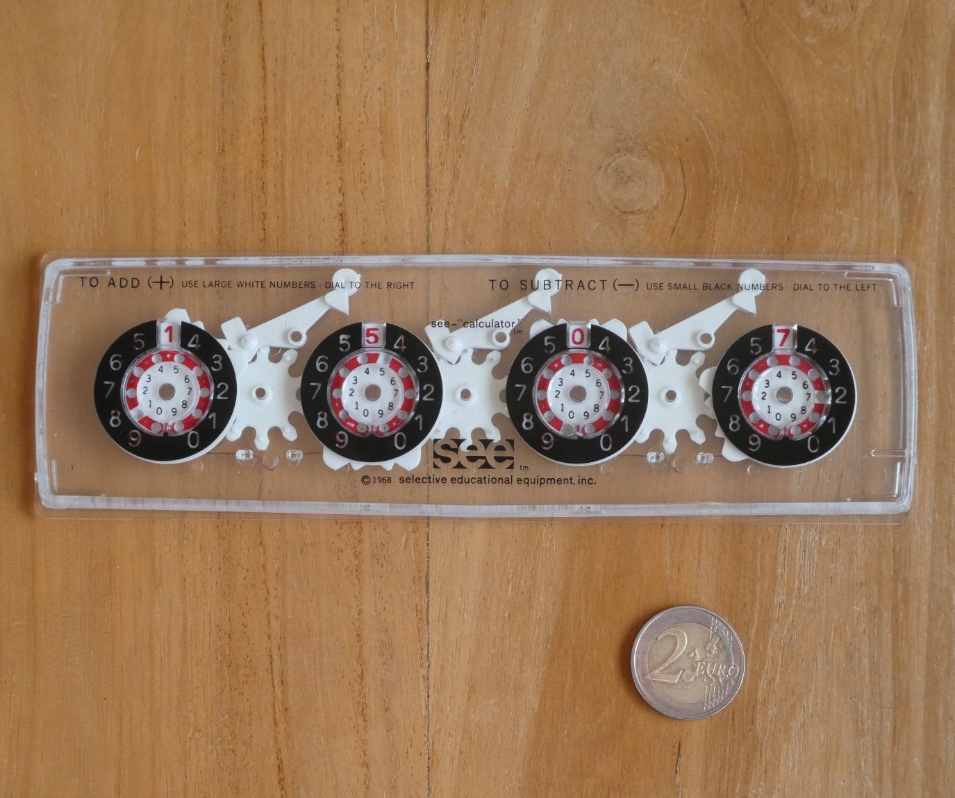Figure 18 — The SEE Calculator: a four-dial Dial-A-Matic in a transparent case, made for teaching. The carry wheels between the dials are visible.