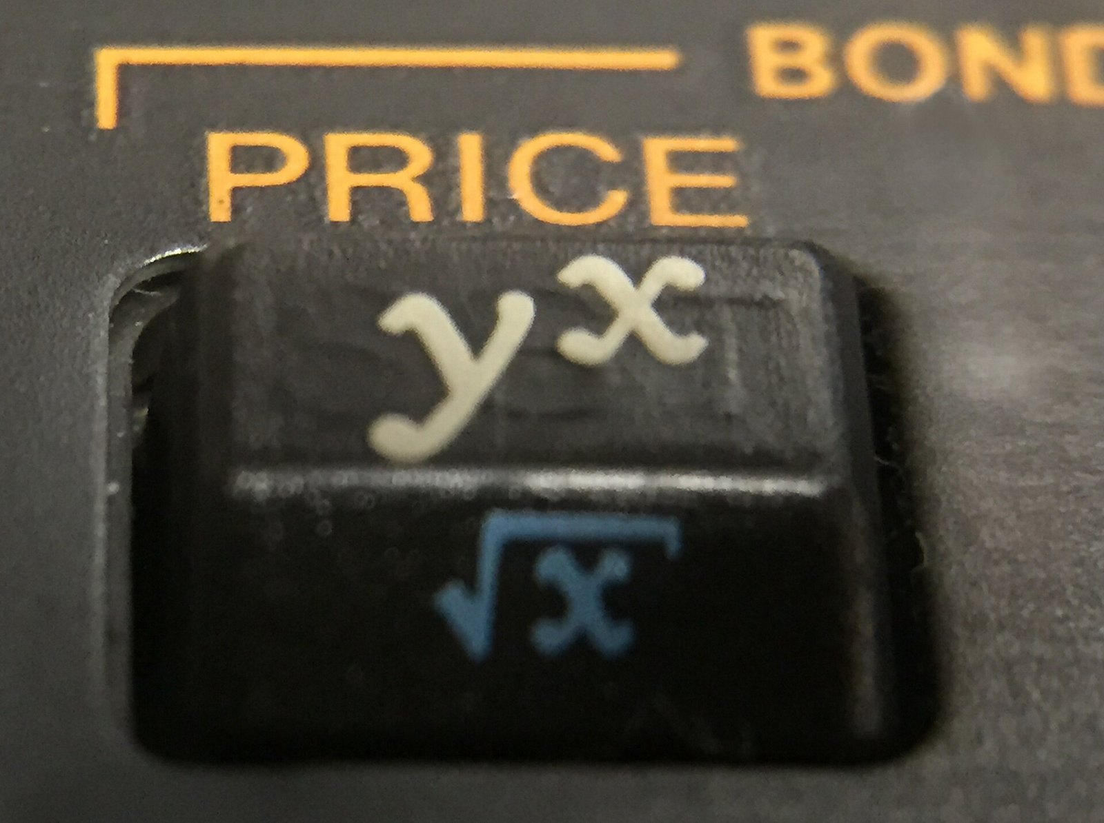 Figure 3 — The y^x key of a 12C, with the gold PRICE label above it and the blue √x below.