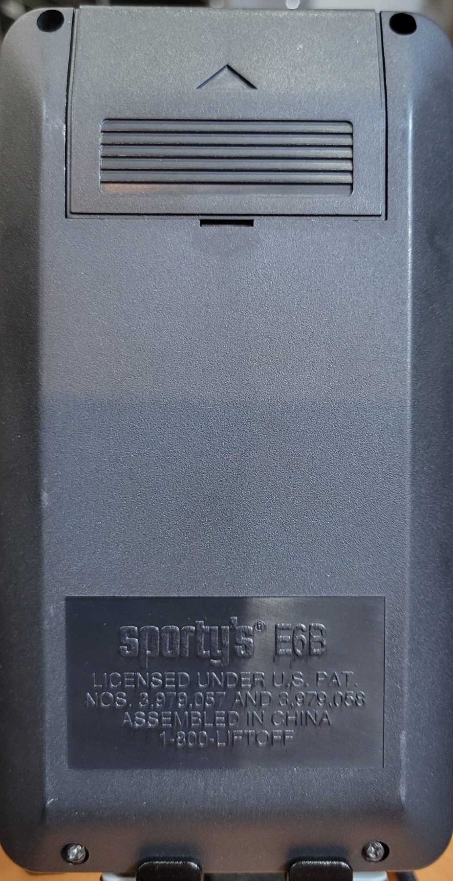 Figure 3 — The back of my E6B: the battery cover at the top and the plate with the two patent numbers and Sporty's old telephone number, 1-800-LIFTOFF.