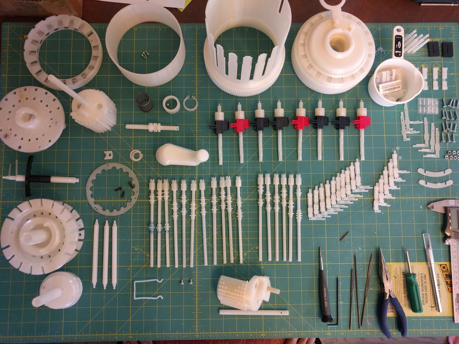 Figure 13 — The machine laid out in pieces. Around 240 printed parts and roughly a hundred non-printed items — screws, springs, balls — make up the finished calculator.
