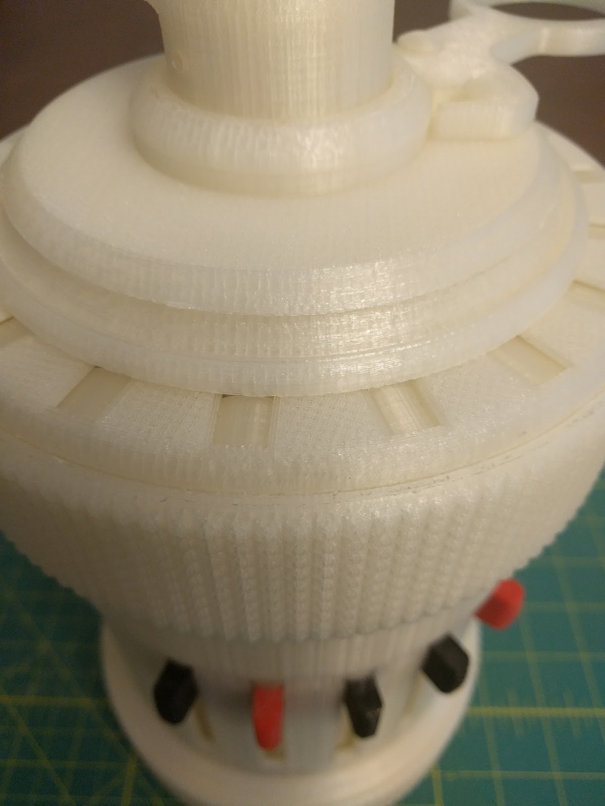 Figure 9 — From the side, with the carriage seated. The visible print layers are the clearest reminder of how the object was made.