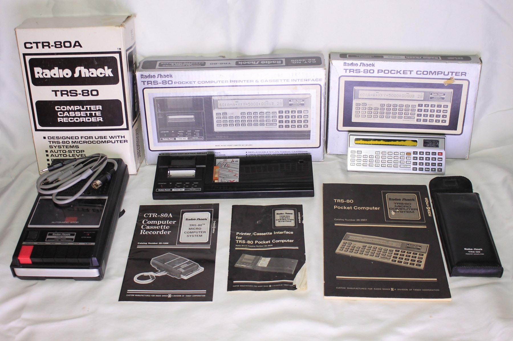 Figure 8 — The PC-1 and its whole family: the Pocket Computer and its manuals, the Printer/Cassette Interface, the Cassette Interface, and Radio Shack's CTR-80A recorder, all in their boxes.