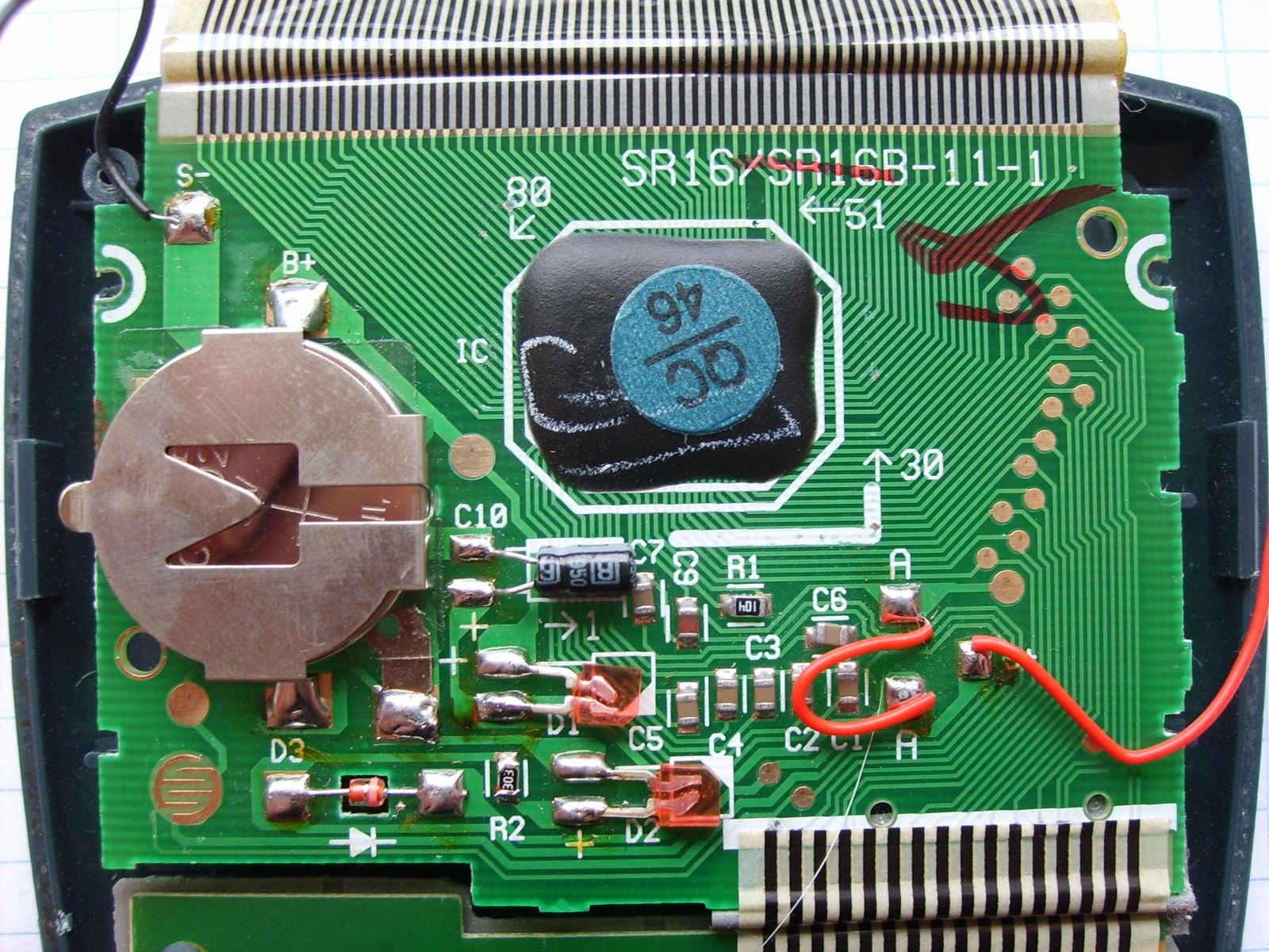 Figure 5 — The board of a TI-30X IIS, with its button-cell holder and the flexible connector to the display.