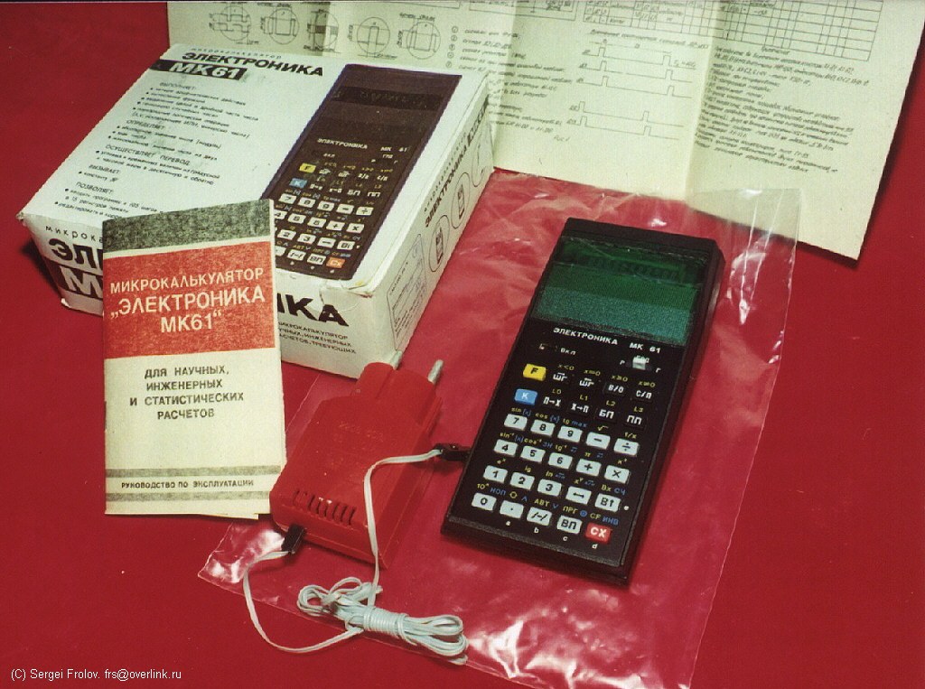 Figure 3 — A complete MK-61 set: the calculator, its manual, the box and the Д2-10М mains adapter.