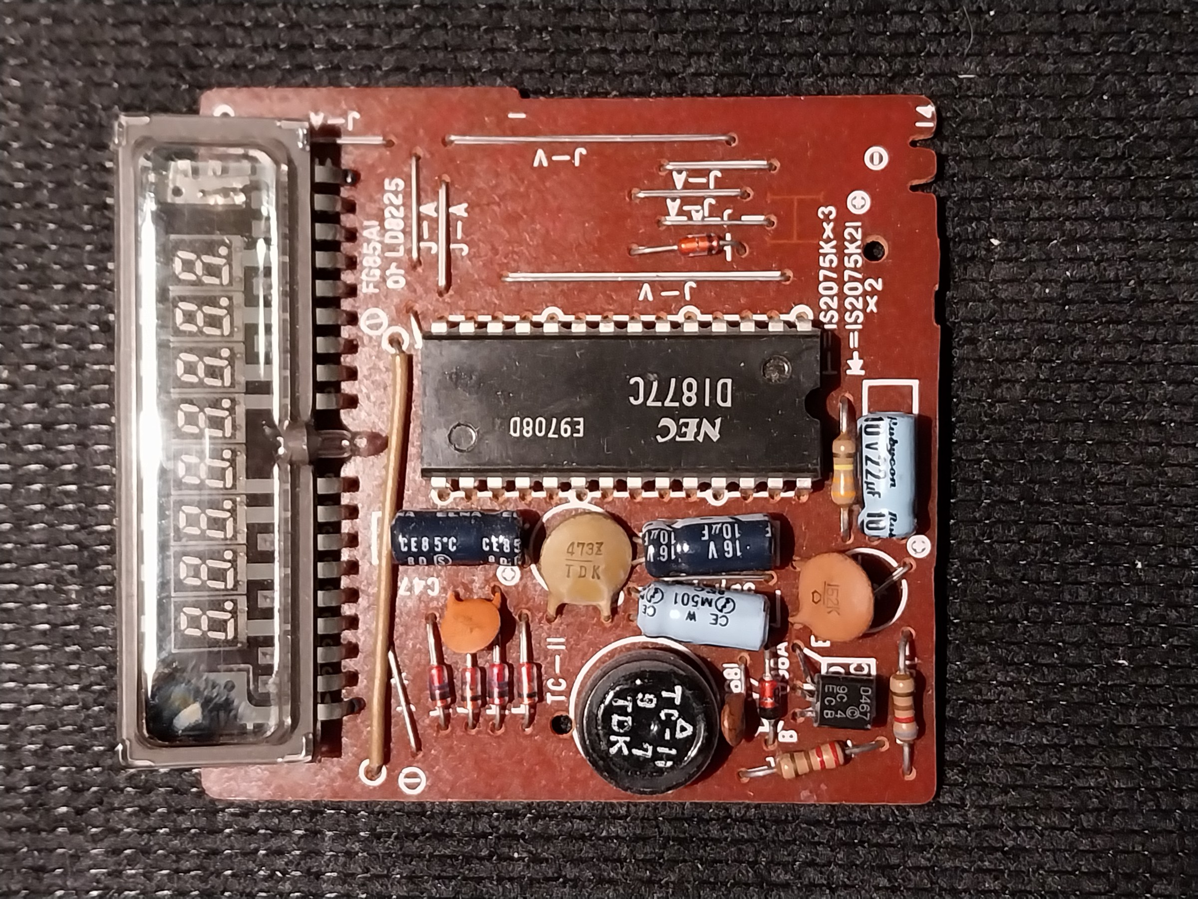 Figure 30 — The circuit board of a Casio M-1 calculator, with its multi-digit fluorescent tube mounted at the edge, its calculator chip and its small converter.