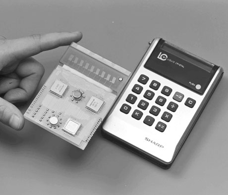 Figure 29 — The end of the pocket VFD: Sharp's EL-805 of 1973, the first liquid-crystal calculator, which ran for about 100 hours on one AA cell, beside the electronics that made it possible.