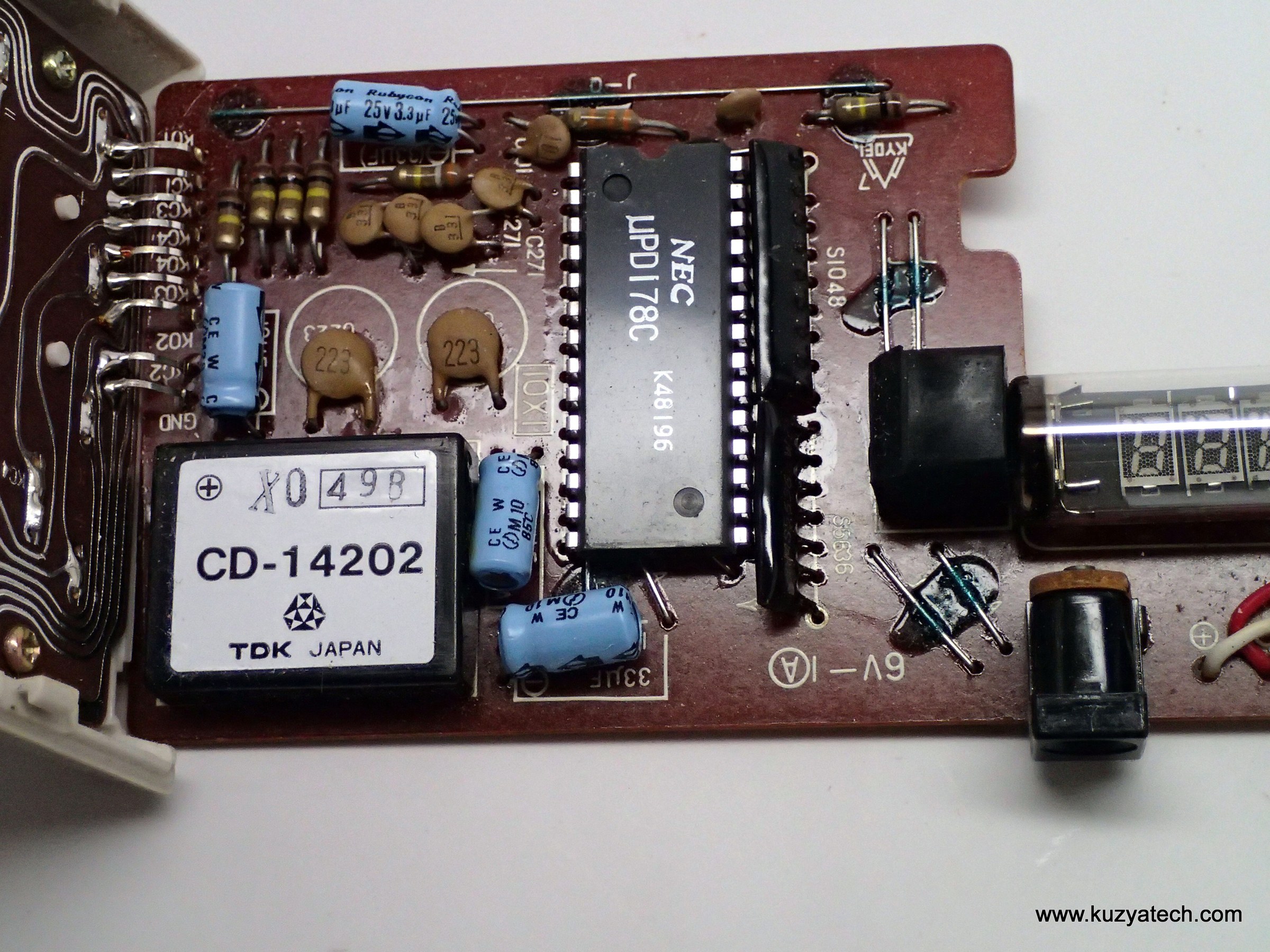 Figure 8 — The NEC µPD178C calculator chip of a Casio Personal-mini, the converter module beside it and the tube at the edge of the board: a complete calculator in three parts.